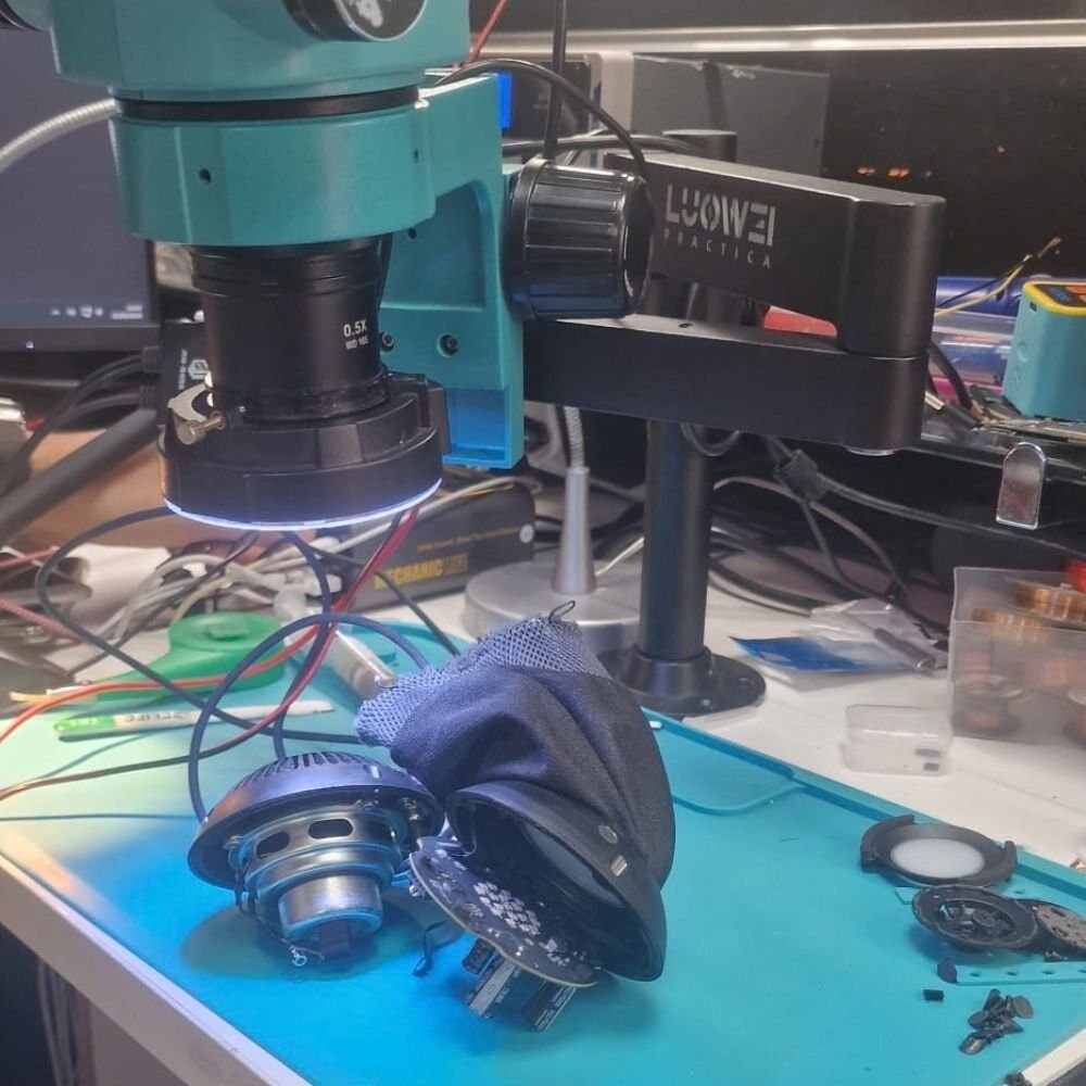 Técnico realizando diagnóstico electrónico en la placa de un HomePod mini